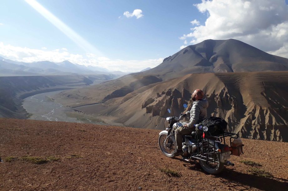 homme sur moto devant paysage du Ladakh en Inde