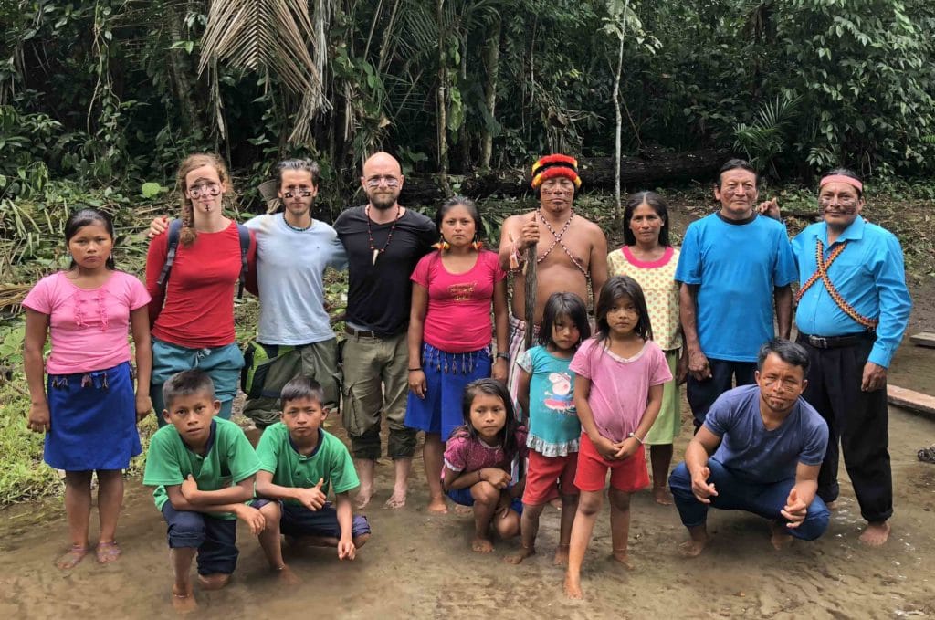 Groupe d'Achuar et voyageurs les pieds dans la rivière dans la foret amazonienne en voyage en Équateur