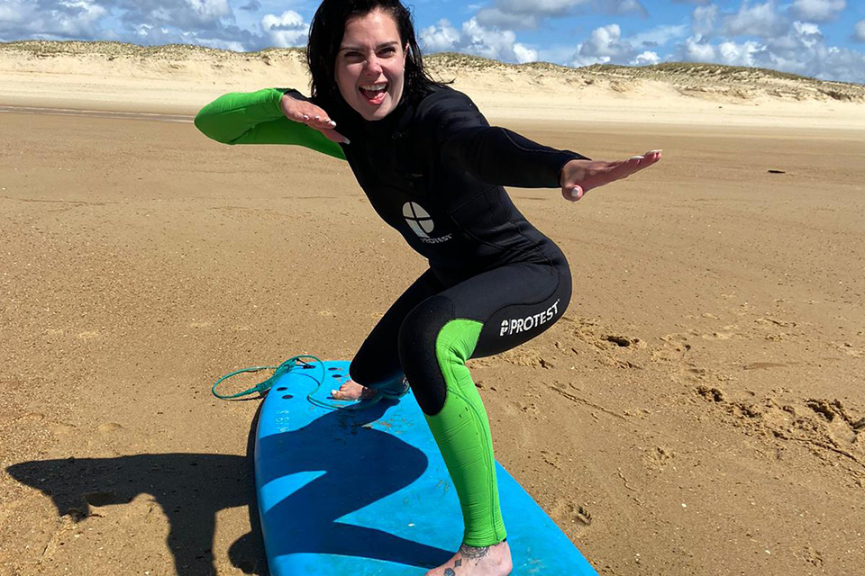 Jeune femme sur une planche de surf sur la plage